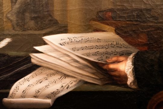 Eine Detailansicht eines Gemäldes von Joseph Haydn mit Notenblättern.