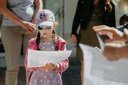 Mädchen in Sonnenbrillen schaut eine Zeichnung an