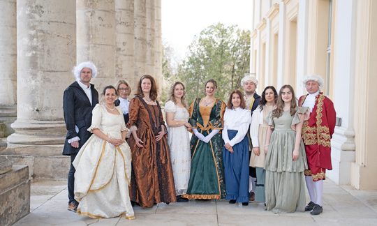 Menschen stehen im Kostüm neben dem Schloss Esterházy