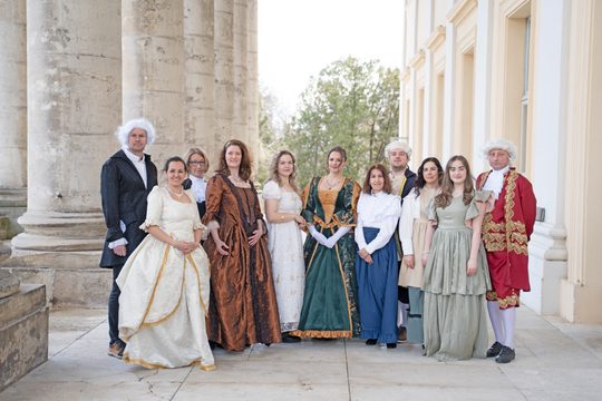 Menschen stehen im Kostüm neben dem Schloss Esterházy