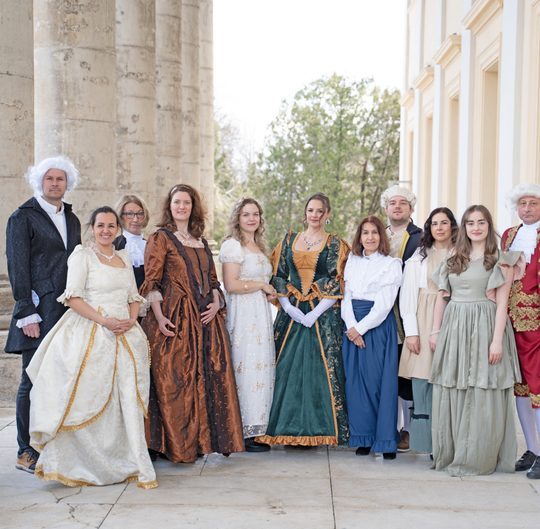 Menschen stehen im Kostüm neben dem Schloss Esterházy