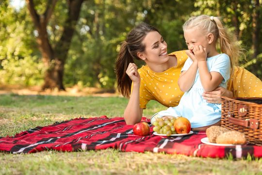 Mutter mit Kind auf Picknickdecke