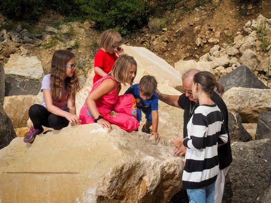Kinder sitzen auf Steinen im Steinbruch St. Margarethen
