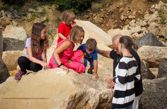 Kinder sitzen auf Steinen im Steinbruch St. Margarethen