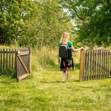 Frau mit Picknick Rucksack bei Holzzaun