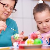 Frau und Kind bemalen Ostereier