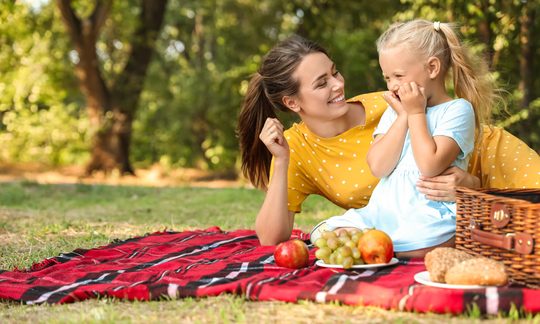 Mutter mit Kind auf Picknickdecke