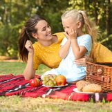 Mutter mit Kind auf Picknickdecke